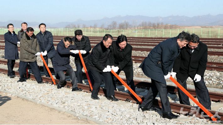 ▲26일 오전 개성 판문역에서 진행된 '동·서해선 남북 철도·도로 연결 및 현대화 착공식'에서 남북 관계자들이 궤도 체결식을 갖고 있다. (사진=사진공동취재단)