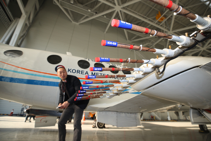 지난 24일 오후 서울 강서구 김포공항 국제선 격납고에서 인공강우 실험에 쓰일 기상청 기상항공기와 실험에 쓰이는 연소탄을 국립기상과학원 연구관이 설명하고 있다. 기상청과 환경부는 25일 서해상에서 인공강우의 미세먼지 저감 효과를 분석하는 합동 실험을 한다. (사진=연합뉴스)