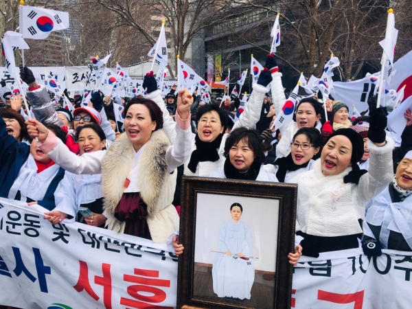 ▲1일(현지시각) 천안시 대표로 참석한 유영분 여성정책팀장이 유관순열사 영정을 들고 김동복 한국여성경제인협회 세종충남지회장, 박현정 부회장과 함께 미국 다그 함마슐드 광장에서 열린 독립만세 운동 재현행사에 참여하고 만세를 외치고 있다. (사진=천안시청)