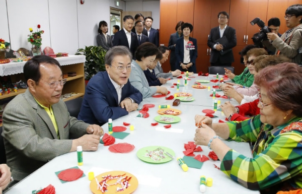 ▲문재인 대통령이 7일 오전 금천구 치매안심센터에서 치매어르신 및 가족들과 카네이션을 만들며 대화하고 있다. (사진=연합뉴스)