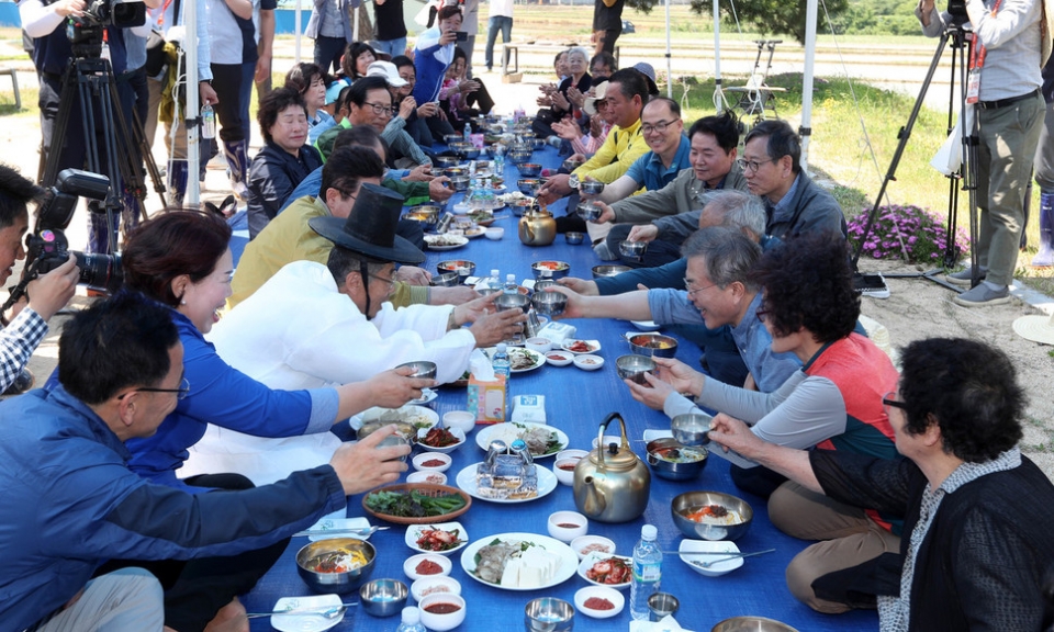 ▲문재인 대통령이 24일 경북 경주시 옥산마을에서 모내기를 한뒤 마을 주민과 새참을 하고 있다. (사진=청와대사진기자단)