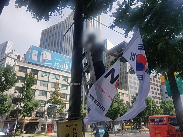▲ 6일 오후 3시 30분쯤 서울 중구 대한문 인근 도로에 내걸었던 '노 재팬(No Japan)' 현수기가 철거되고 있다. (사진=조선일보)