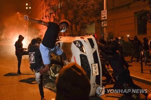 흑인 남성 사망 사건에 분노한 시위대가 지난달 31일(현지시각) 워싱턴DC 백악관 인근에서 차량을 부수고 있다. (사진=워싱턴 AP 연합뉴스)