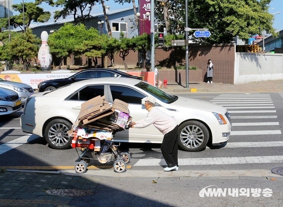 ▲ 서울 영동대교 북단 뚝섬로에서 한 노인이 폐지를 실은 유모차를 끌고 역주행 하고 있다. (사진= 내외방송 정수남 기자)