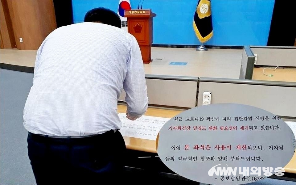 ▲ 국회 공보실 직원이 거리두기 안내문을 기자회견장 좌석에 부착하고 있다. (사진=내외방송 정수남 기자)