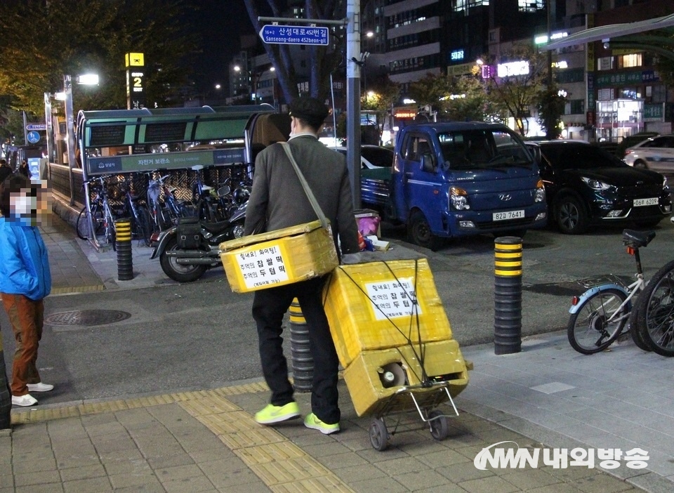 ▲ 26일 퇴근길. 서울지하철 8호선 남한산성역 출구 인근에서 옛날 교복을 입은 찹쌀떡 장수가 출현했다. 찹쌀떡과 메밀묵은 1960년대부터 1980년대 겨울철 야식으로 톡톡한 역할을 했다. 당시 찹쌀떡 장수들은 이슥한 밤, 골목골목을 돌며 “찹쌀떡 사려, 메밀묵”을 소리 높여 외쳤다. 카메라에 잡힌 찹쌀떡 장수는 메밀묵 대신 두텁떡을 판다. (사진=내외방송 정수남 기자)