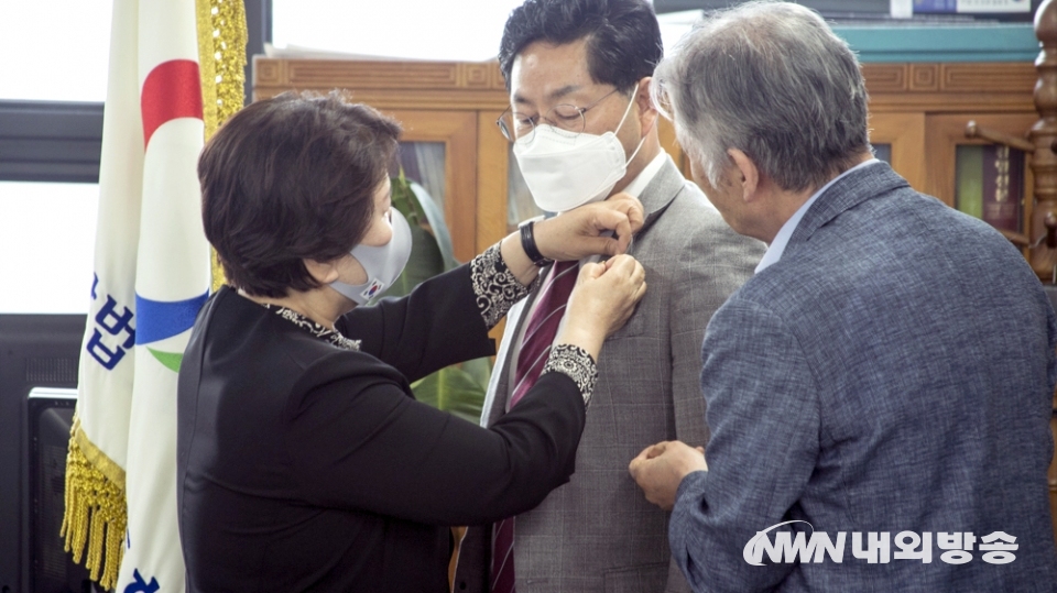 ▲ 천상덕 이사장에게 국민통합 뱃지를 달아주고 있는 서정숙 전임 이사장.