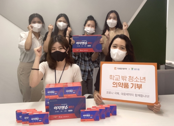 ▲ 학교 밖 청소년들에게 기부할 이지엔6에이스를 들고 기념촬영을 하는 대웅제약 임직원들 (사진=대웅제약 제공)