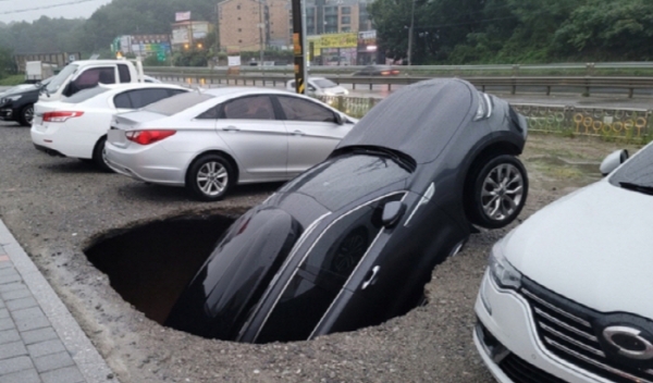 ▲ 9월 1일 오전 충남 당진시 서해로 한 공터에 대형 지반침하(싱크홀)가 발생해 차량 1대 차체 절반이 빠져 있다. (사진=연합뉴스)