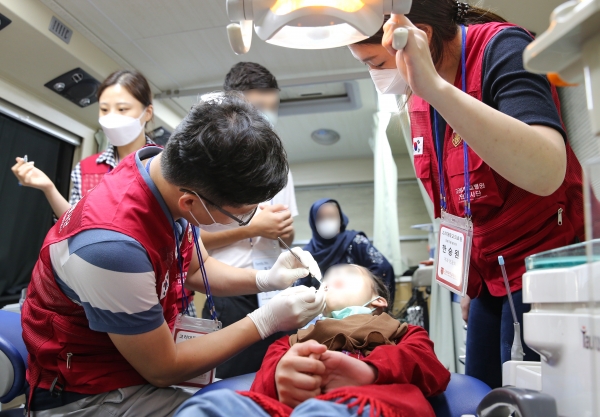 ▲ 안암병원 치과 송인석 교수(왼쪽 제일 앞)가 아프간 아동을 치료하고 있다 (사진=고대의료원 제공)