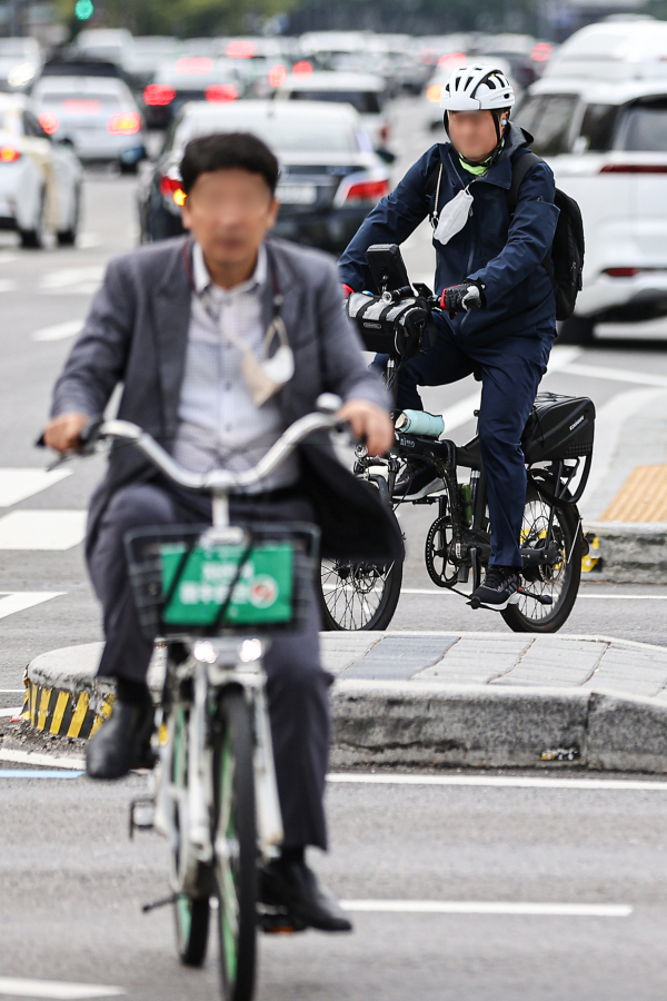 26일 오전 서울 종로구 광화문역 인근에서 시민들이 마스크를 벗고 자전거로 출근을 하는 모습. (사진=연합뉴스)