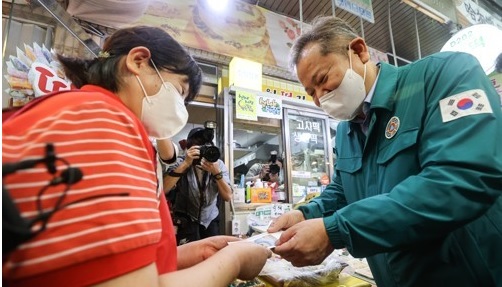 이상민 행정안전부 장관이 지난해 9월 관악구 신사시장을 찾아 떡을 구매하고 있다.(사진=연합뉴스)