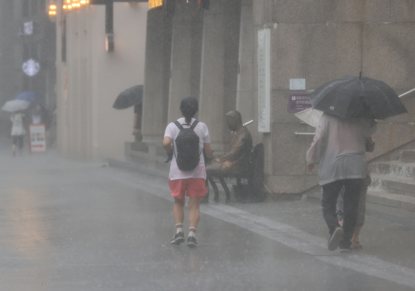 9일 광화문 광장에 비가 내리자 한 시민이 비를 맞으며 이동하고 있다.(사진=연합뉴스)