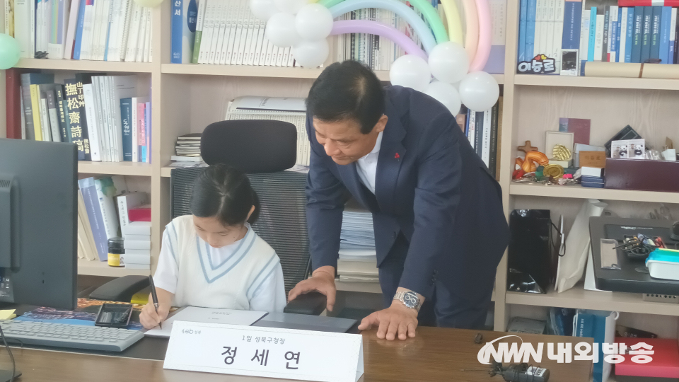 서울 성북구 '1일 구청장실'에 참여한 어린이가 직접 서류에 결재를 하고 있다. 오른쪽은 이승로 성북구청장. (사진=임동현 기자)